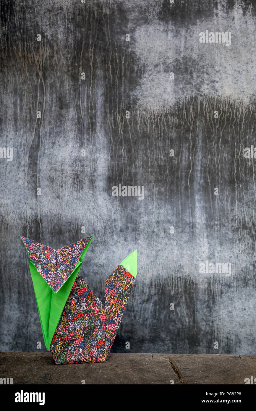 Origami fox nella parte anteriore della parete di cemento Foto Stock