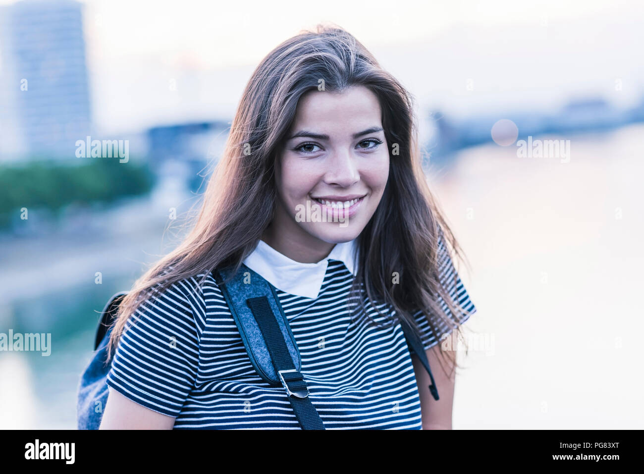 Ritratto di sorridente giovane donna con capelli lunghi marrone Foto Stock