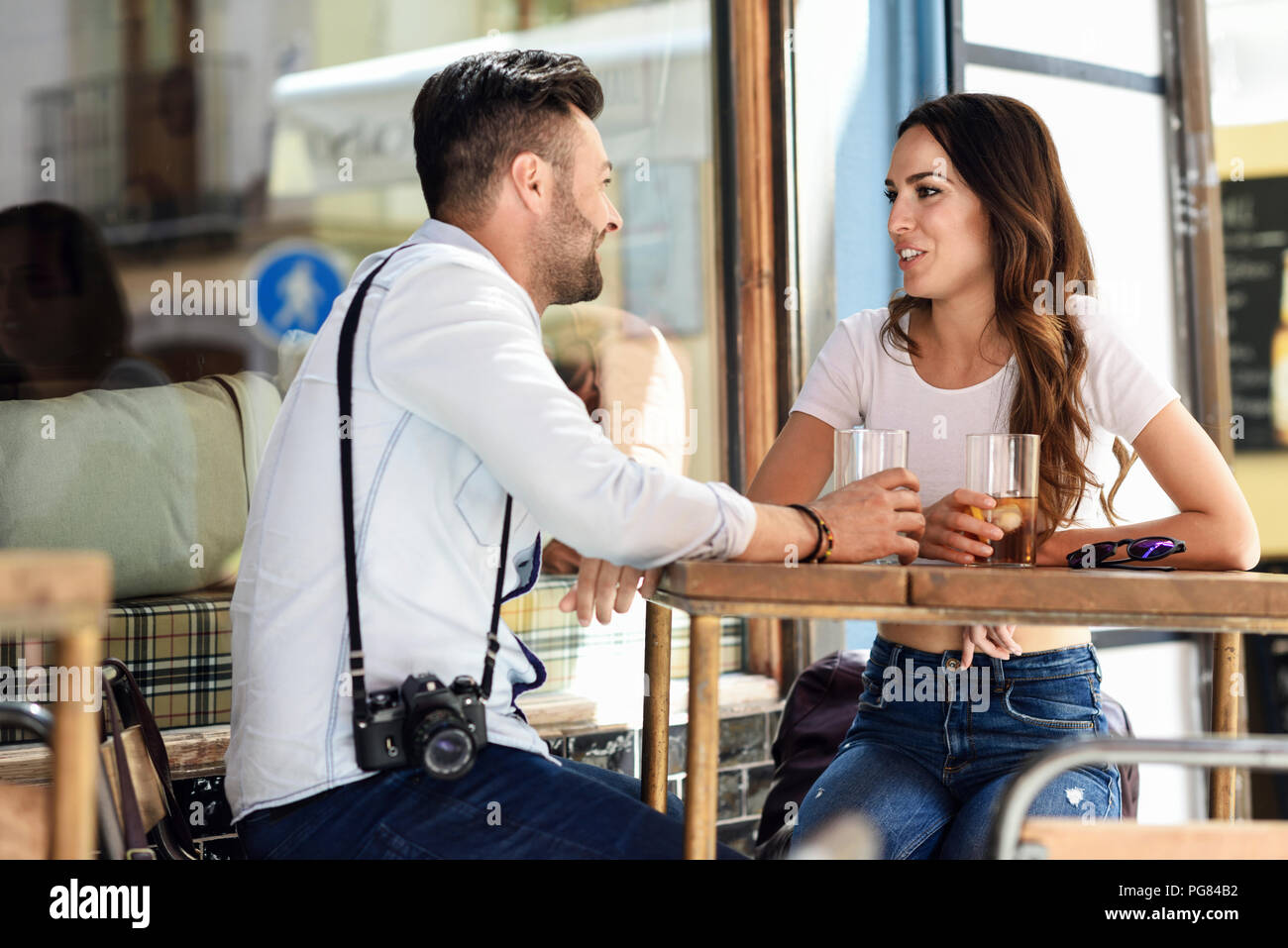 Coppia avente un drink in un bar all'aperto nella città Foto Stock