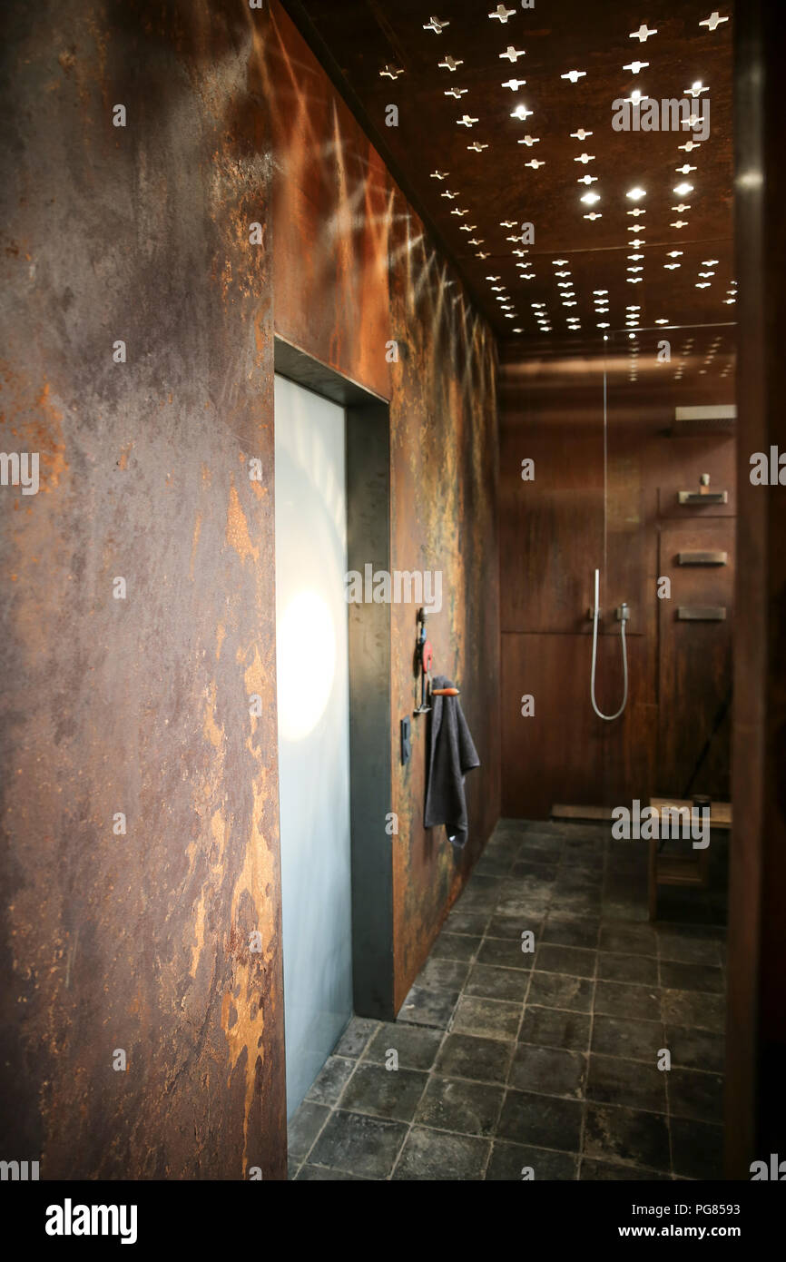 Bagno moderno con acciaio corten rivestimento pareti e soffitto effetti di luce Foto Stock