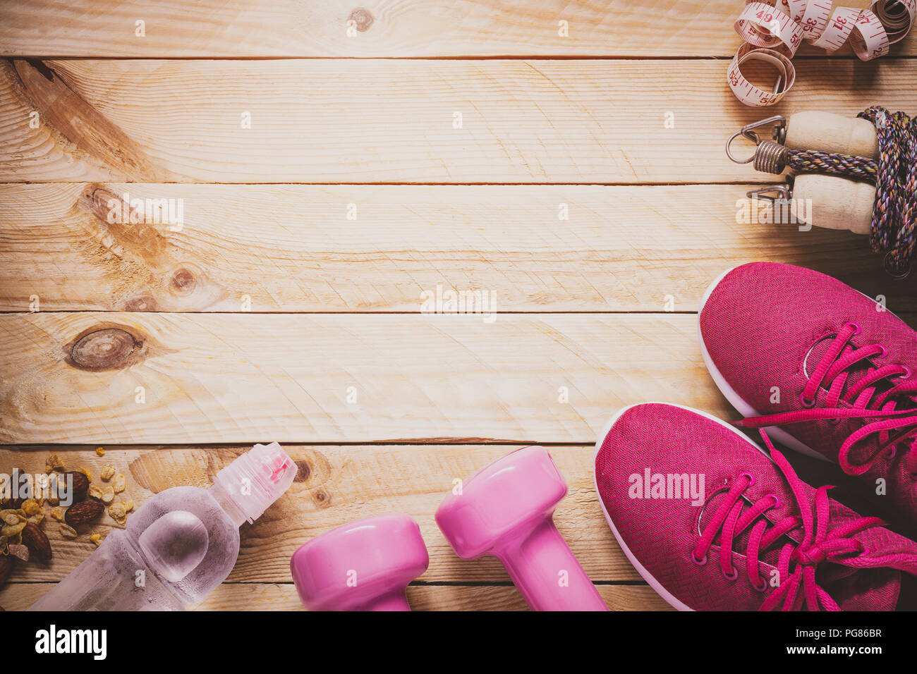 La cura del corpo e della bellezza, peso e dieta uno stile di vita sano concetto. Attrezzature sportive, manubri, scarpe da running, funi di salto su sfondo di legno. Foto Stock