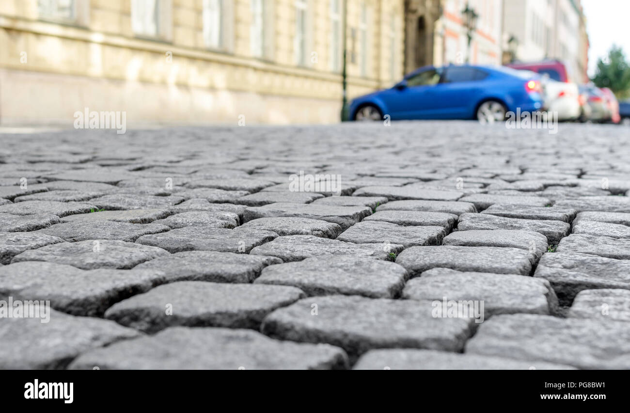 Vecchia strada lastricata di pietra. La texture è chiaramente visibile. Essa può essere considerata parte della strada con parcheggio e case. Foto Stock