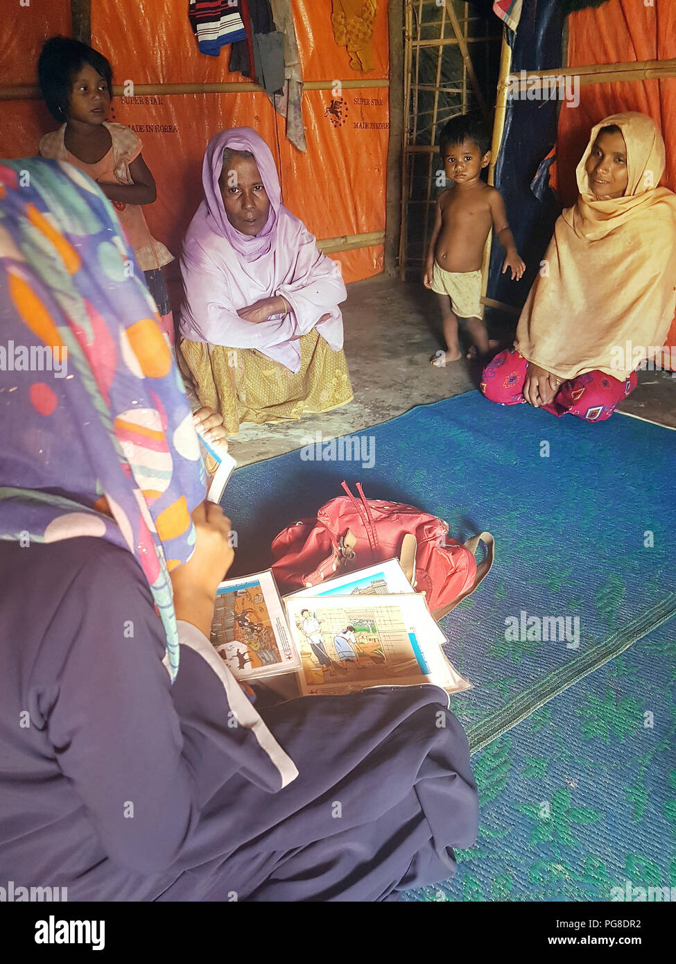 13 agosto 2018, Bangladesh, Cox's Bazar: i dipendenti della Mezzaluna Rossa del Bangladesh spiegare agli abitanti di un Rohingya campo di rifugiati nel loro rifugio quali misure igieniche possono adottare per proteggersi dalle malattie. Foto: Nick Kaiser/dpa Foto Stock