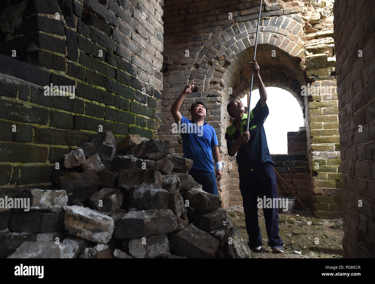 (180824) -- Pechino, 24 agosto 2018 (Xinhua) -- i membri dello staff Zheng Baoyong (L) e Xia Chunyou misurare una gravemente danneggiata da torre a una sezione della grande muraglia costruita nella dinastia Ming (1368-1644), a nord del villaggio di Donggou Miyun nel distretto di Pechino, capitale della Cina, 22 Agosto, 2018. Una sezione della Grande Muraglia qui è stata gravemente rovinato a causa di uomo e di fattori naturali, e per la riparazione e i lavori di rinforzo ha iniziato quest'anno. Negli ultimi dieci anni il governo di Pechino ha investito 374 milioni di yuan (circa 54,4 milioni di dollari) per riparare e proteggere l'antica muraglia nella r Foto Stock