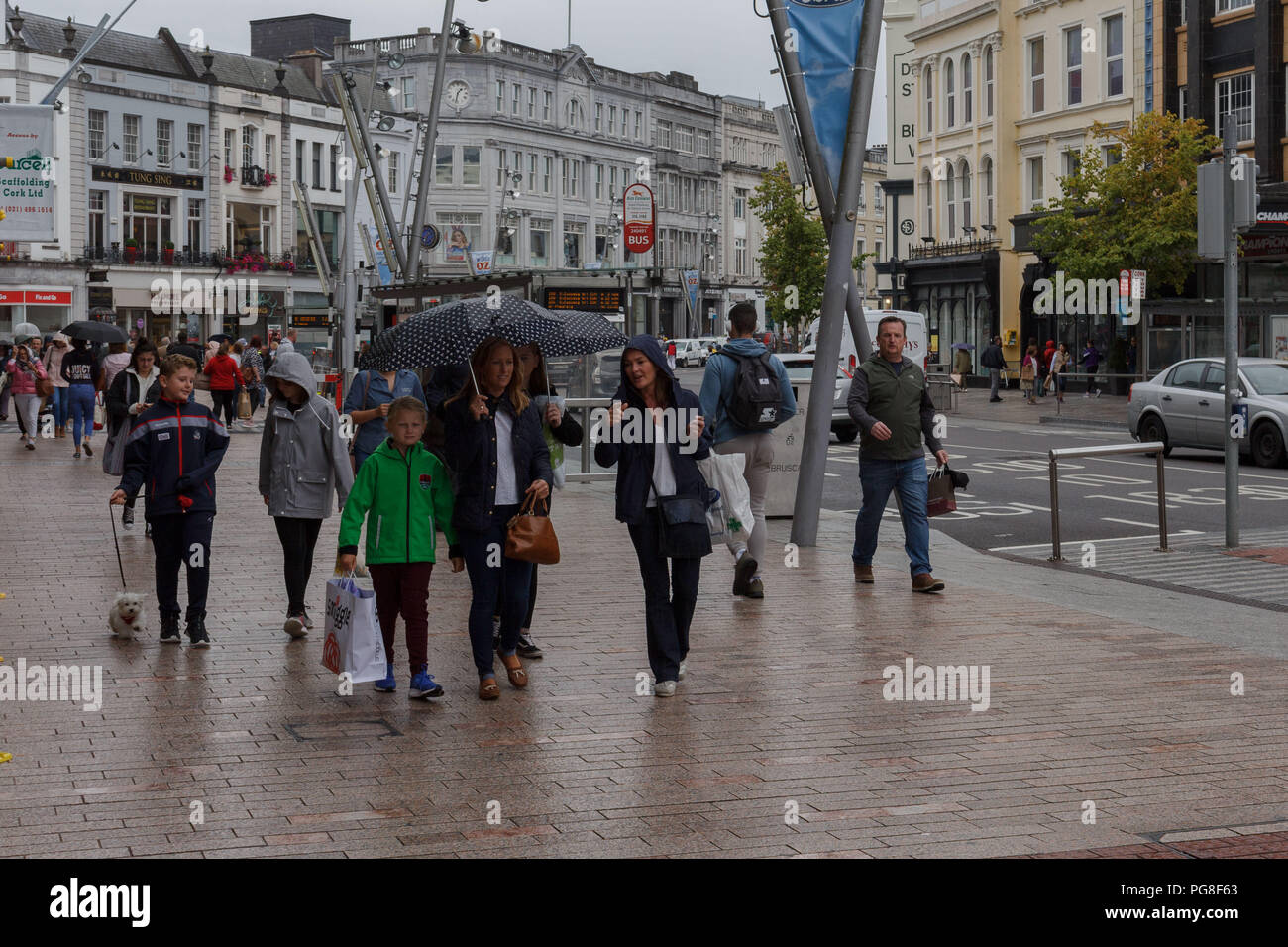 Cork, Irlanda. 24 Ago, 2018. Rainy day per gli acquirenti di St Patrick Street. La pioggia ha restituito alla città di Cork ancora una volta, gli acquirenti speso oggi in esecuzione da negozio a negozio per evitare molte docce che si sono verificati durante tutta la giornata. Credito: Damian Coleman/Alamy Live News. Foto Stock