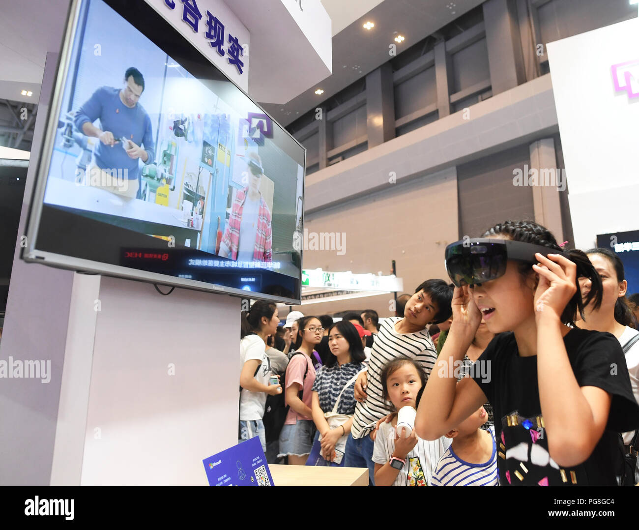 Chongqing. 24 Ago, 2018. Un giovane visitatore indossa una realtà mista (MR) dispositivo durante il primo Smart Cina Expo nel sud-ovest della Cina di Chongqing, 24 agosto 2018. Il primo Smart Cina Expo è qui tenuto dal giovedì al sabato. Credito: Wang Quanchao/Xinhua/Alamy Live News Foto Stock