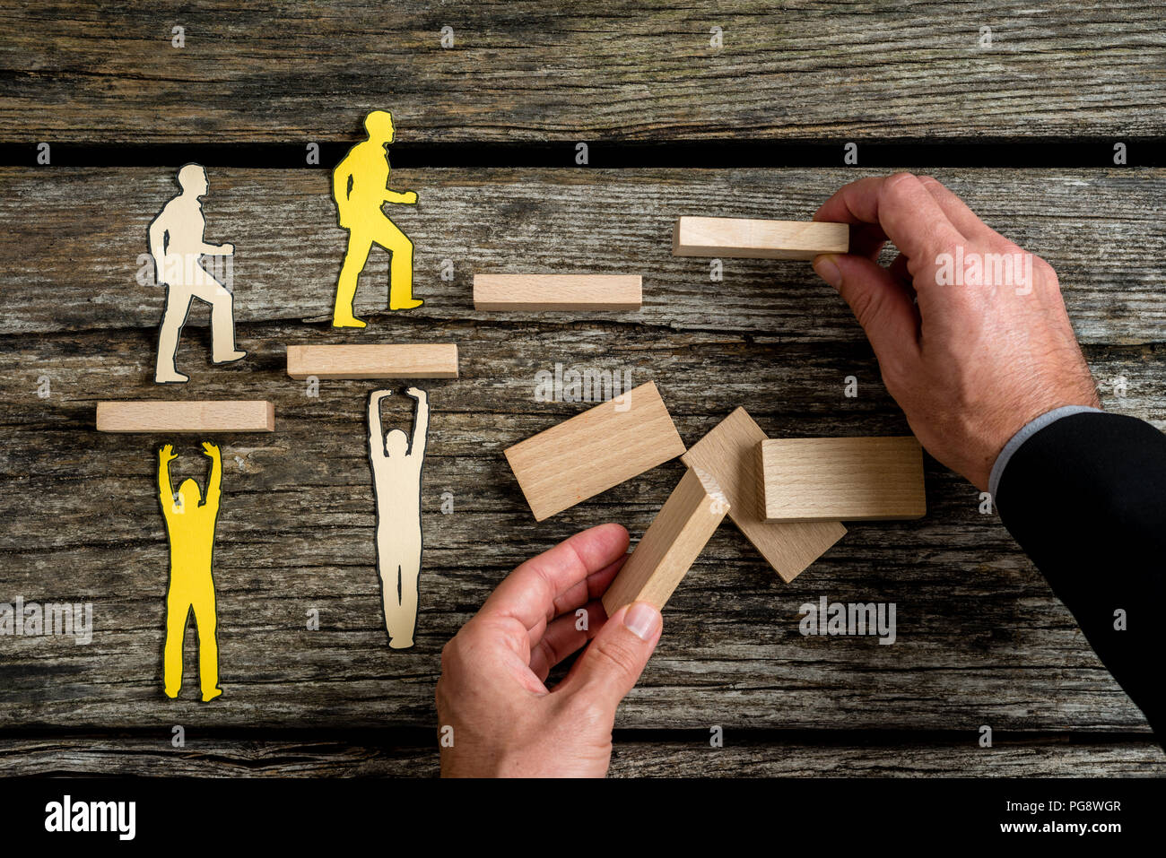 Imprenditore con silhouette persone aiutando gli altri di colore opposto salendo le scale in legno. Foto Stock