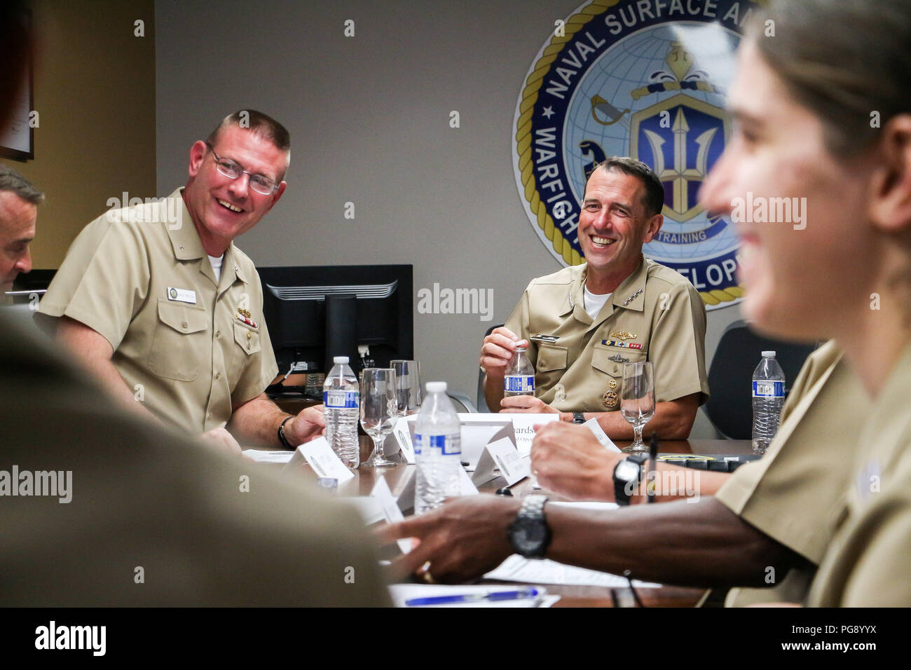 SAN DIEGO (Agosto 22, 2018) Capo di operazioni navali Adm. John Richardson, destra, risate durante una discussione di gruppo durante un briefing alla superficie navale e il mio combattimento Centro di sviluppo (SMWDC). SMWDC è uno della Marina Militare di combattimento di cinque centri di sviluppo e la sua missione è quella di incrementare la letalità e tattica di competenza della forza di superficie tra tutti i domini. (U.S. Navy foto di Lt. Matteo A. Stroup/rilasciato) Foto Stock