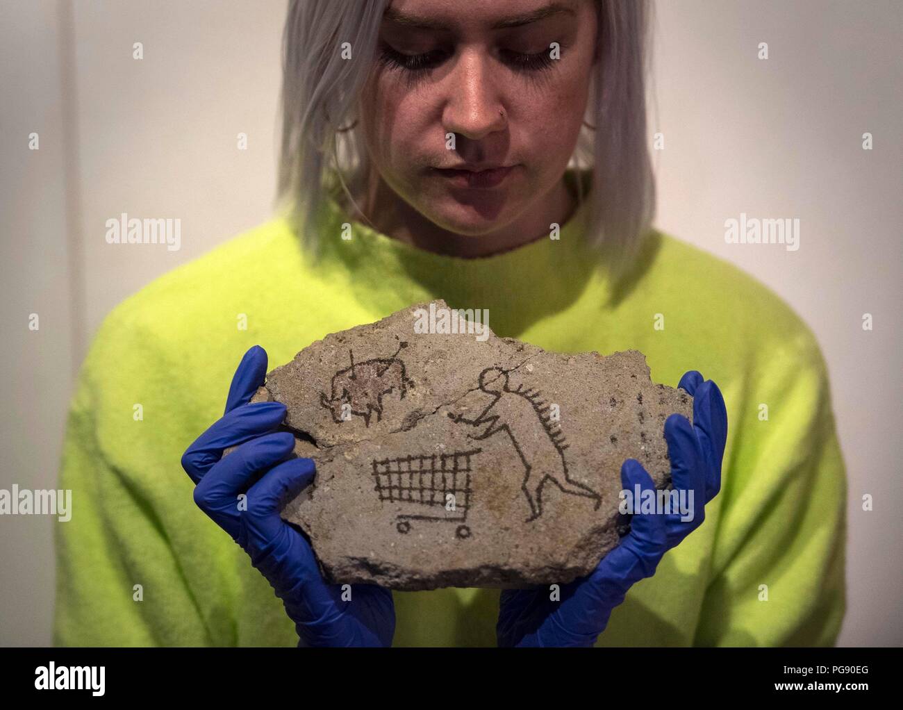 Harriet McColm del Team Collezioni del British Museum prepara il Peckham Rock di Banksy prima dell'installazione al British Museum di Londra. L'artista ha segretamente posto il pezzo storico del simulk in una galleria al museo in 2005, quando è andato inosservato per tre giorni ed ora sta ritornando con permesso come parte di Ian Hislops curata la mostra 'i Object: Ian Hislops cerca il dissenso. Foto Stock