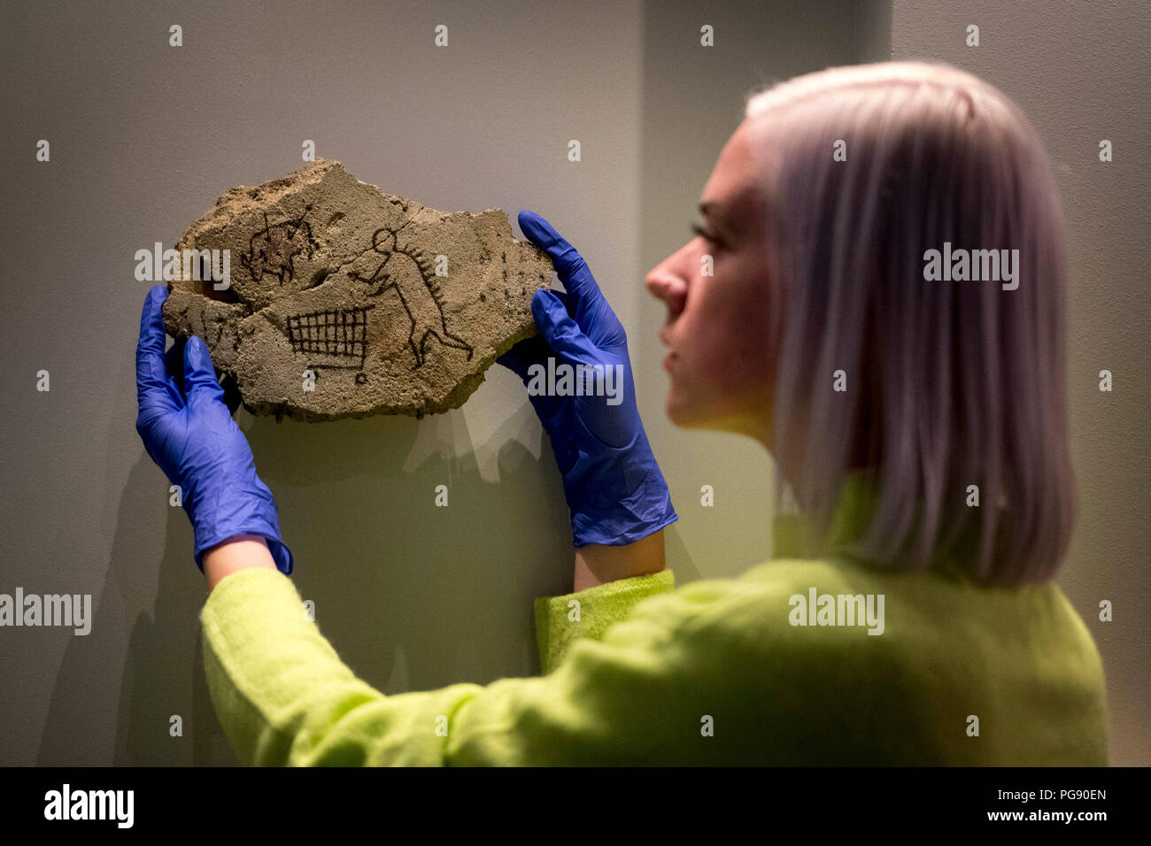 Harriet McColm del team delle collezioni del British Museum prepara il Peckham Rock di Banksy prima dell'installazione al British Museum di Londra. L'artista ha collocato segretamente il pezzo storico mock in una galleria al museo nel 2005, quando è andato inosservato per tre giorni, e ora sta ritornando con il permesso come parte della mostra curata di Ian Hislop 'i object: Ricerca di Ian Hislop per dissenso. Foto Stock