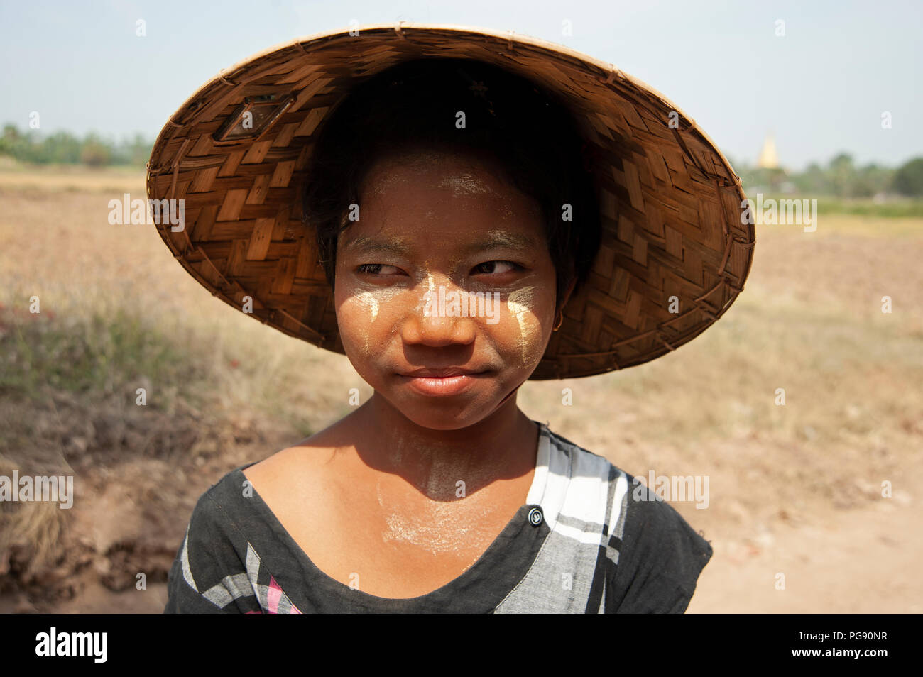 Ritratto di una giovane ragazza birmano indossando un cappello conico in un campo vicino a Mandalay Myanmar Foto Stock