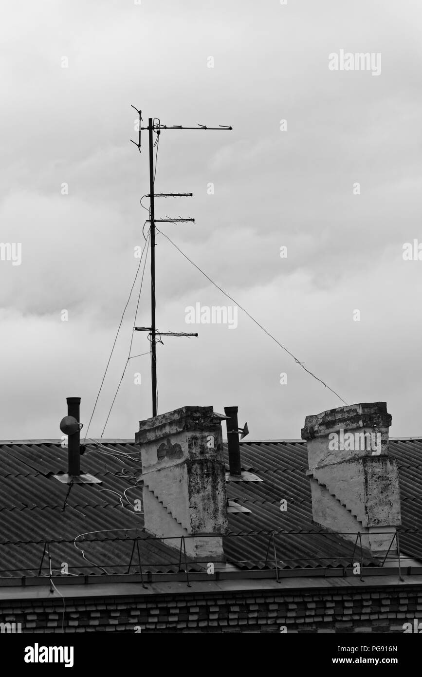 Foto in bianco e nero di camini e antenna televisiva sul tetto di un edificio. Komsomolsk-su-Amure, Russia Foto Stock