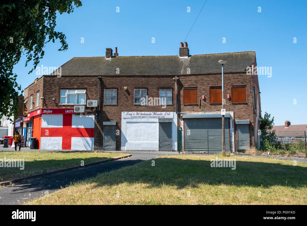 San Giorgio a bandiera dipinta sulla parete della scatola negozi immobiliari, Roma Anagnina, West Midlands. Foto Stock