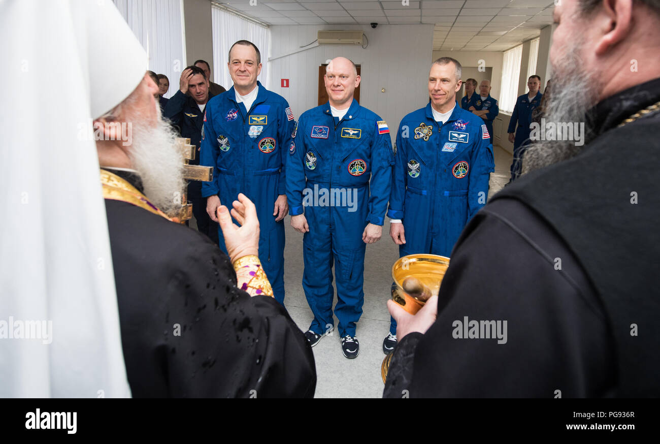 Expedition 55 tecnico di volo Ricky Arnold della NASA, sinistra, Soyuz Commander Oleg Artemyev di Roscosmos, centro e tecnico di volo Drew Feustel, a destra della NASA ricevono la benedizione di un sacerdote russo ortodosso al cosmonauta Hotel prima di uscire dall'hotel per il lancio di un razzo Soyuz, mercoledì 21 marzo, 2018 di Baikonur in Kazakhstan. Arnold, Artemyev e Feustel lancerà nel loro Soyuz MS-08 navicella spaziale alla Stazione Spaziale Internazionale a cinque mesi di missione. Foto Stock