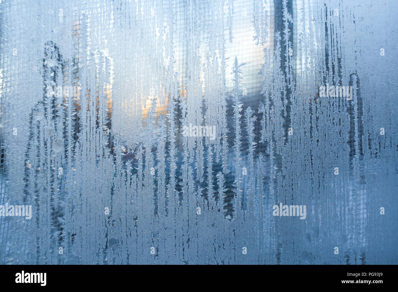 Bizzarro bianco verticale frosty motivi sulla finestra d'inverno. Disegni di ghiaccio come bande a lungo. Foto Stock