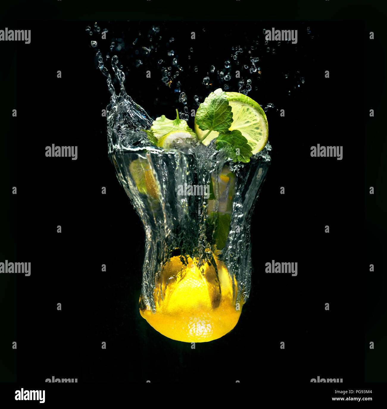 Cocktail Mojito in vetro immaginario con spruzzi di acqua da limone su sfondo nero Foto Stock