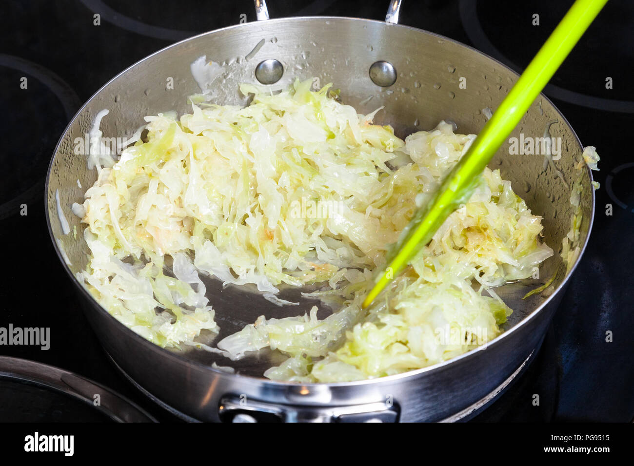 La cottura della torta - brasare il cavolo per il ripieno in padella Foto Stock