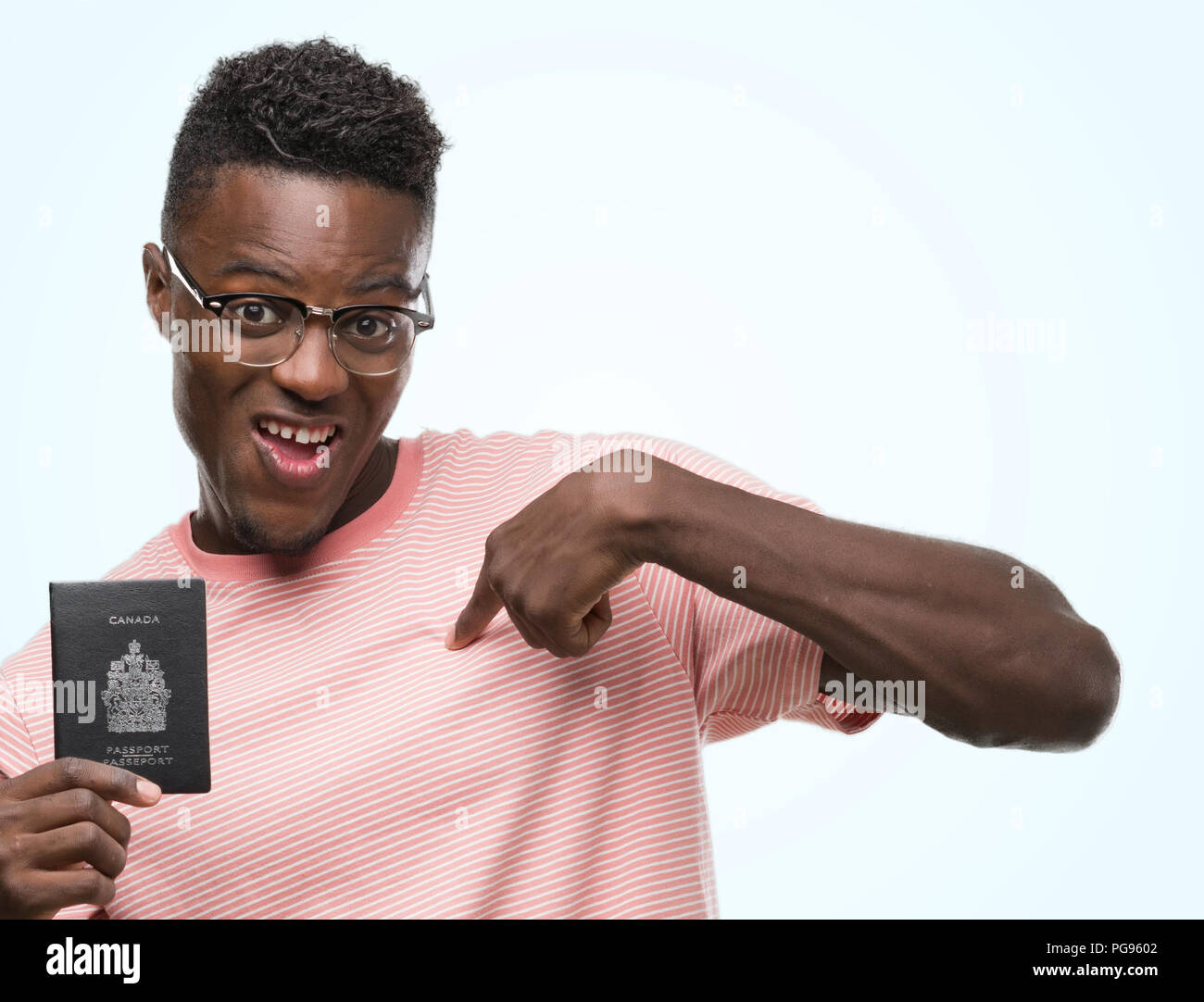 Giovane americano africano uomo con passaporto canadese con sorpresa faccia puntare il dito a se stesso Foto Stock