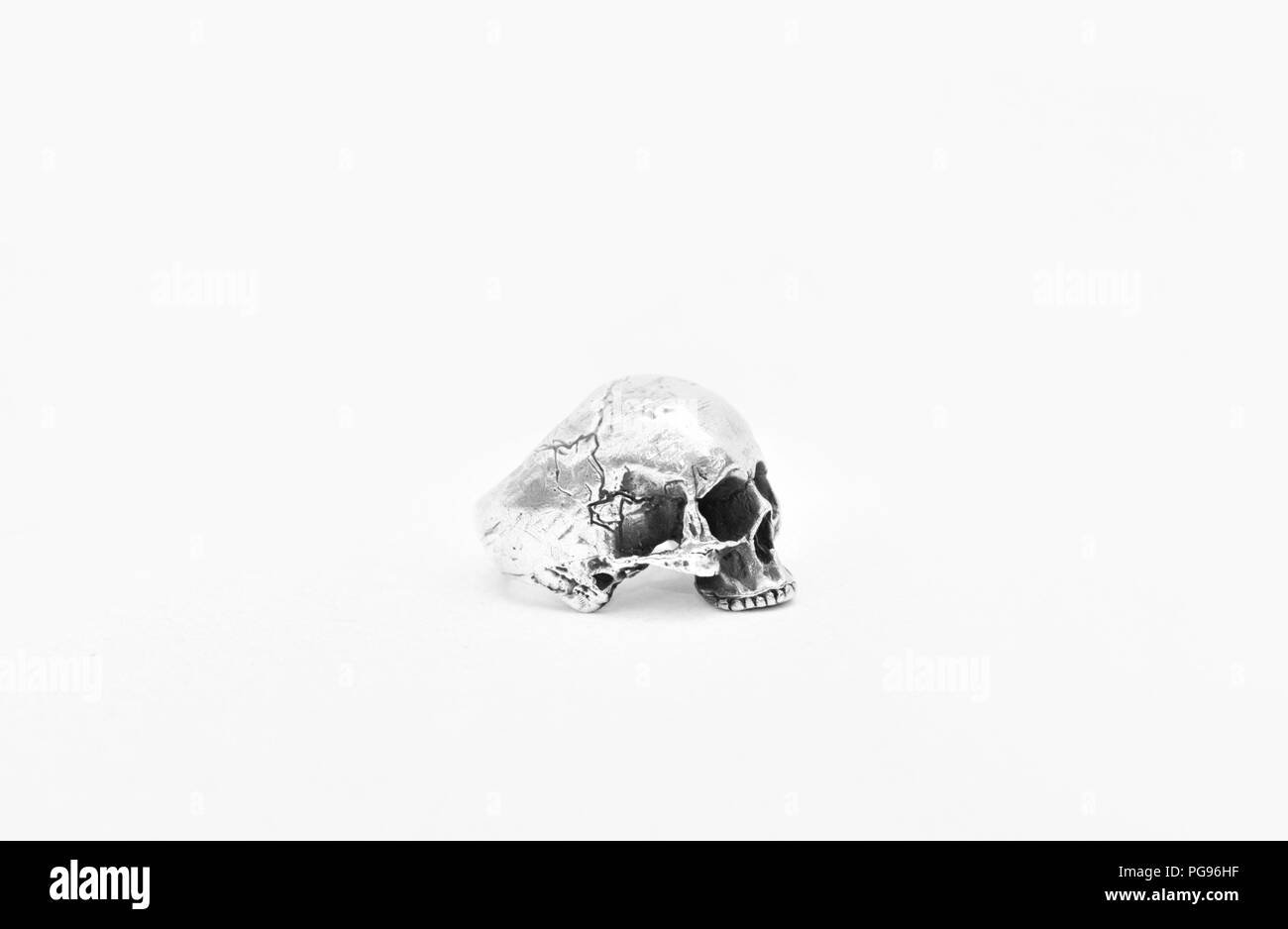 Foto in bianco e nero di argento anello teschio su sfondo bianco. Foto Stock