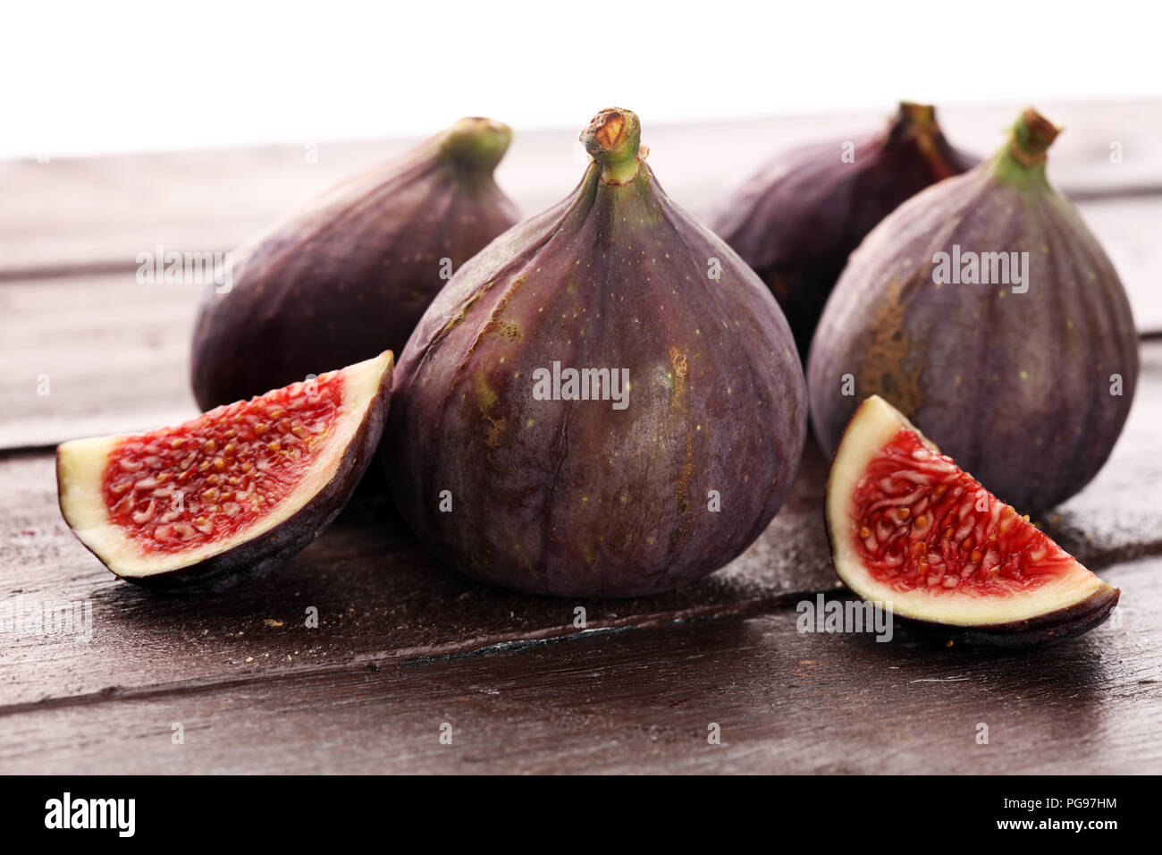 Fichi freschi. Foto di cibo. intera e fette di figure su sfondo rustico Foto Stock