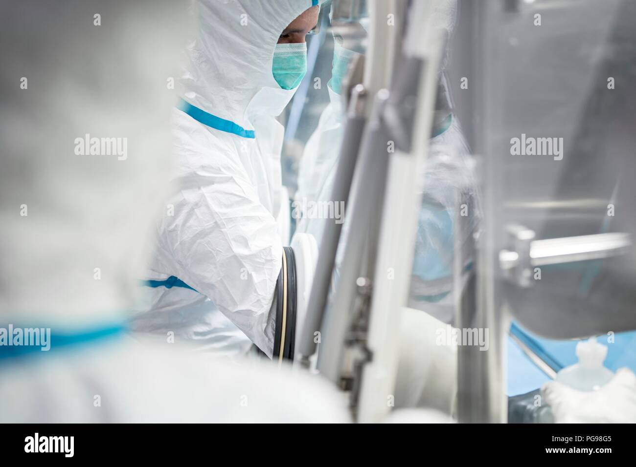 I tecnici al lavoro in sterile sigillato unità isolatore in un laboratorio che produce tessuti umani per l'impianto. Tali tessuti comprendono osso e trapianti di pelle. Foto Stock