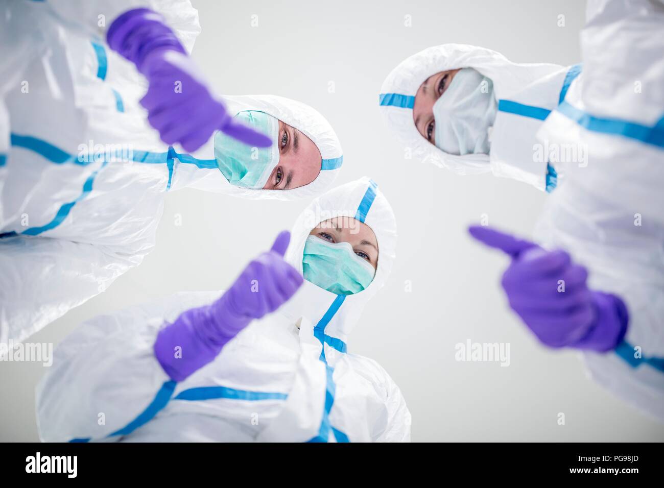 Tecnici di laboratorio in un ambiente sterile dando il pollice in alto segno. Foto Stock