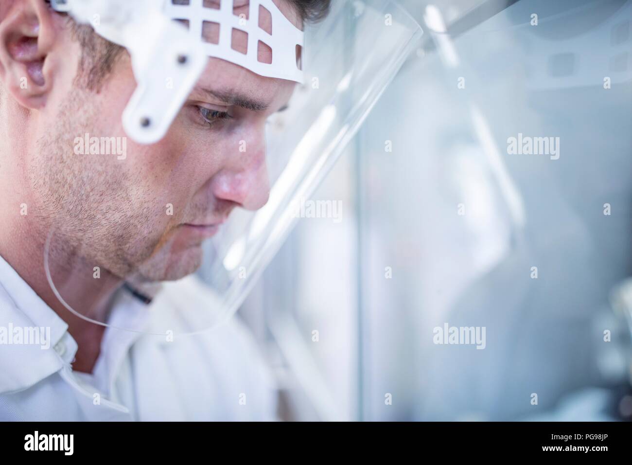 Tecnico di laboratorio indossare una visiera di protezione. Foto Stock
