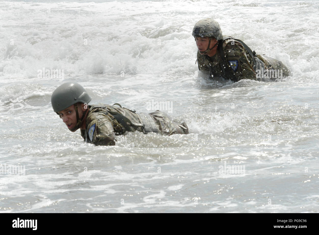 Esercito di Oregon Guardia Nazionale Spc. Roger Spagna (sinistra), con società D, 741st ingegnere vigili del Battaglione, e SPC. Edward Semanski (a destra), con l'Azienda B, 898th ingegnere vigili del Battaglione, alta strisciare attraverso il surf durante la spiaggia di Omaha evento come parte del 2018 Oregon Guardia Nazionale guerriero migliore concorrenza, Agosto 18, 2018 a Camp Rilea in Warrenton, Oregon. I concorrenti provenienti da più Oregon Guardia Nazionale di unità in tutto lo stato sono stati testati su fisicamente e mentalmente impegnativi compiti guerriero durante l'evento di tre giorni per determinare il soldato e sottufficiale dell'anno. (Nazione Foto Stock