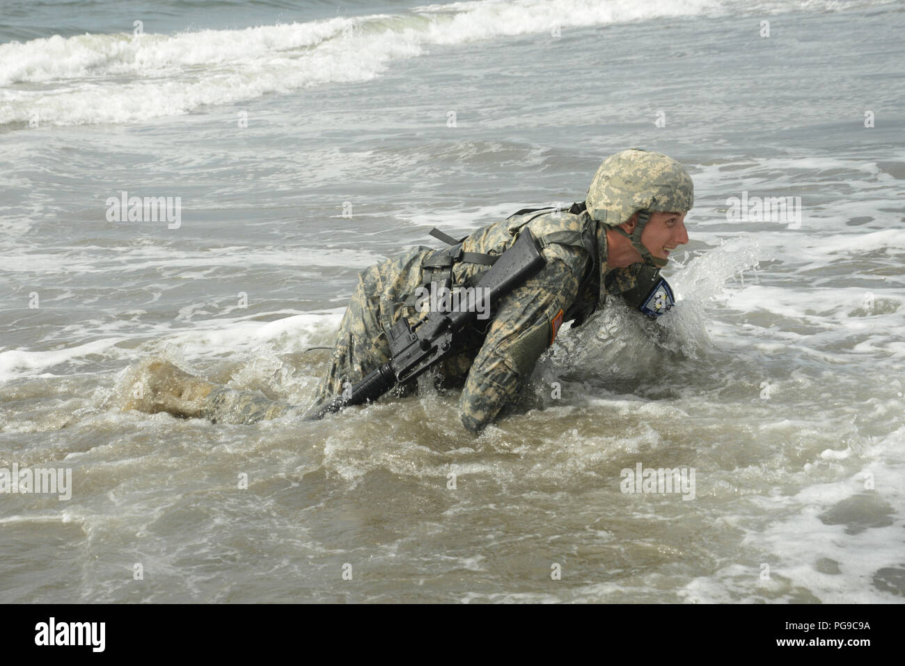 Oregon esercito nazionale del personale di guardia Sgt. Ciro Naugle, con componente 3670th riparazione della società, alta strisciare attraverso il Pacific Ocean surf durante la spiaggia di Omaha evento come parte del 2018 Oregon Guardia Nazionale guerriero migliore concorrenza a Camp Rilea in Warrenton, Oregon, il 18 agosto 2018. I concorrenti provenienti da più Oregon Guardia Nazionale di unità in tutto lo stato sono stati testati su fisicamente e mentalmente impegnativi compiti guerriero durante l'evento di tre giorni per determinare il soldato e sottufficiale dell'anno. (Guardia Nazionale foto di Master Sgt. John Hughel, Oregon Dipartimento militare federale pubblica un Foto Stock