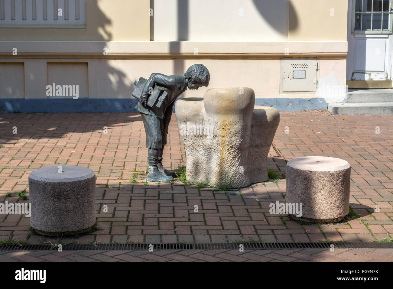 La scultura di un ragazzo che guarda nel pozzo di conoscenze, situato vicino ad una delle scuole di Szeged in Ungheria. Foto Stock