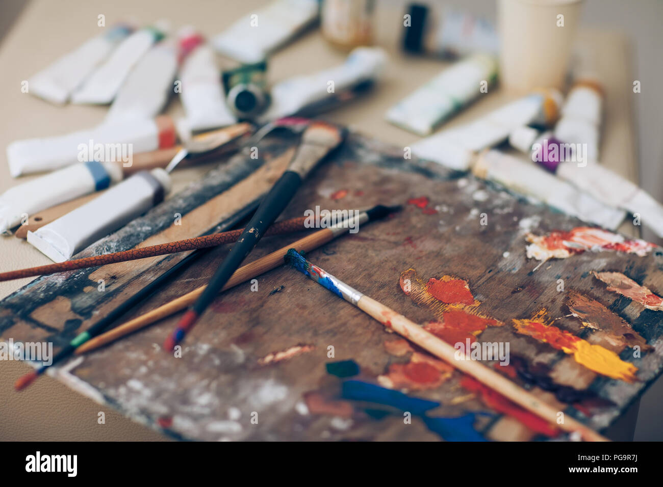 Artista tavolozza, close-up. Spazzole con vernici, vari strumenti dell'artista in disordine di lavoro. Laboratorio Creativo, pittura, arte Foto Stock