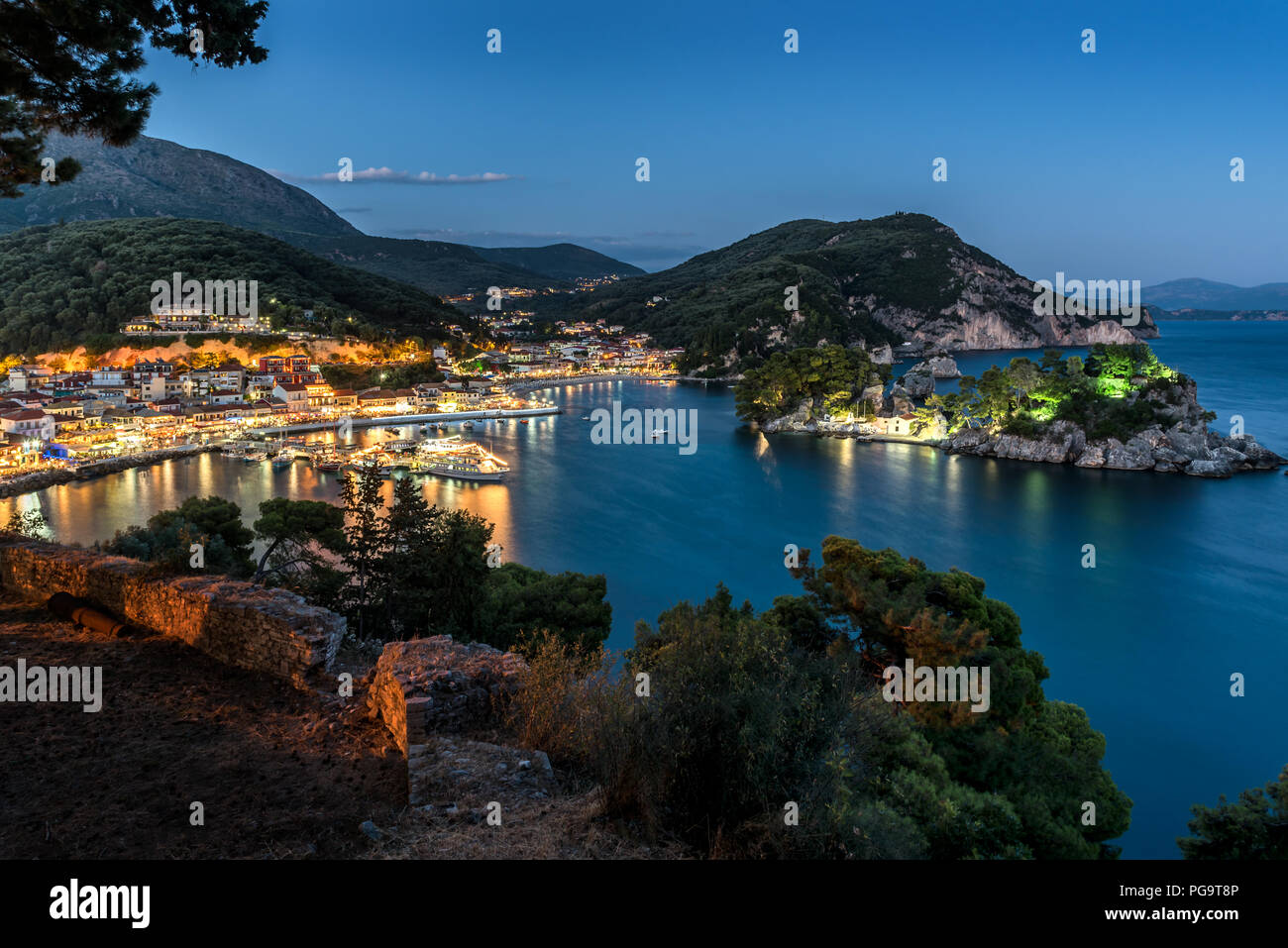 Vista panoramica della cittadina di Parga, il porto, la spiaggia e gli isolotti al blue ora (Regione di Epiro, Grecia) Foto Stock