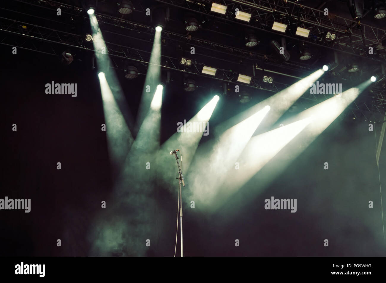 Microfono in attraversato le luci spot sul vuoto stadio scuro prima del concerto Foto Stock