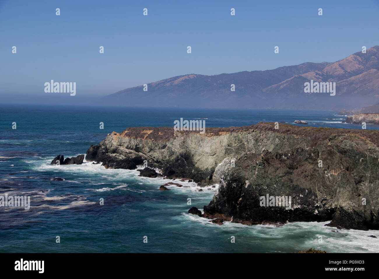 Panoramica Costiera vista dell'oceano pacifico. Montagne, onde e lussureggiante erba. California west coast paesaggio. Foto Stock