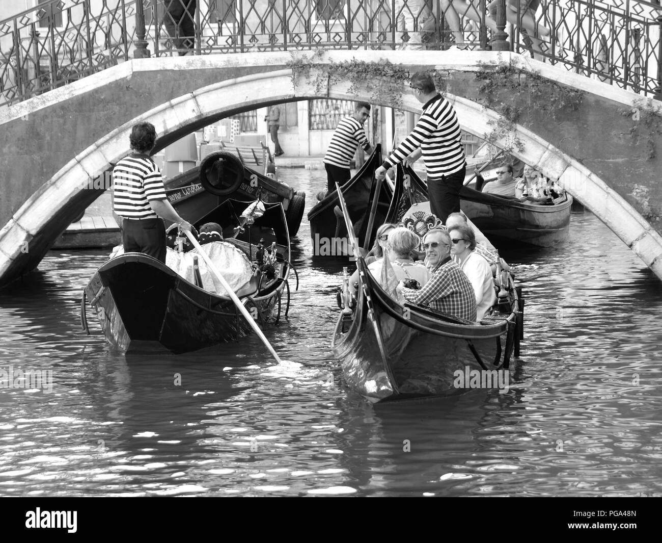 Venezia, Italia - 22 settembre 2016: tipica scena su un canale di Venezia, le gondole venete con gondolieres e turisti fodera fino alla croce sotto un bri Foto Stock