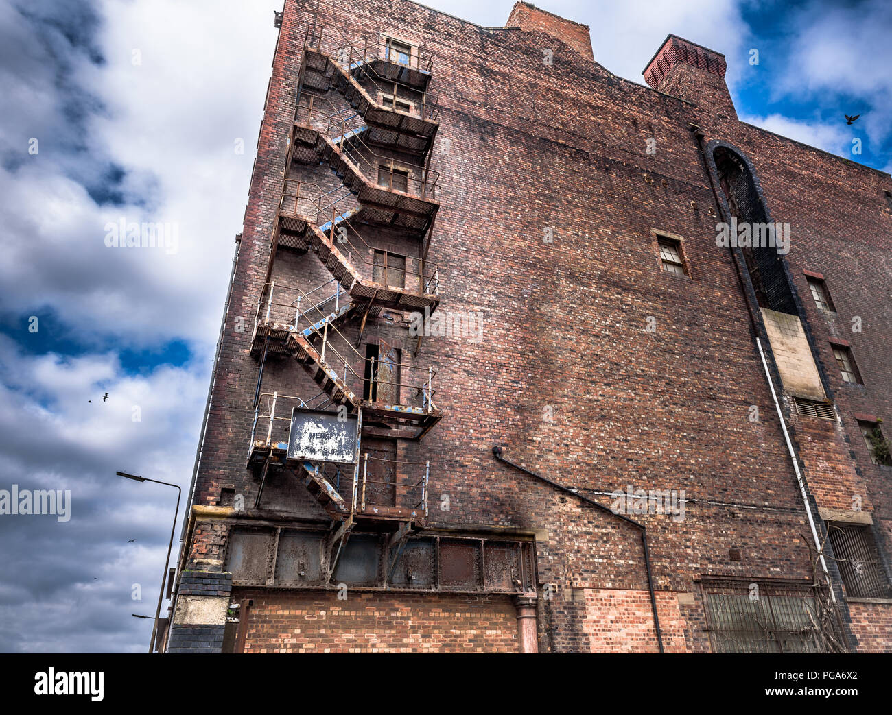 Vecchio di ferro arrugginito sulla scala di un magazzino abbandonato a Liverpool docks. Foto Stock