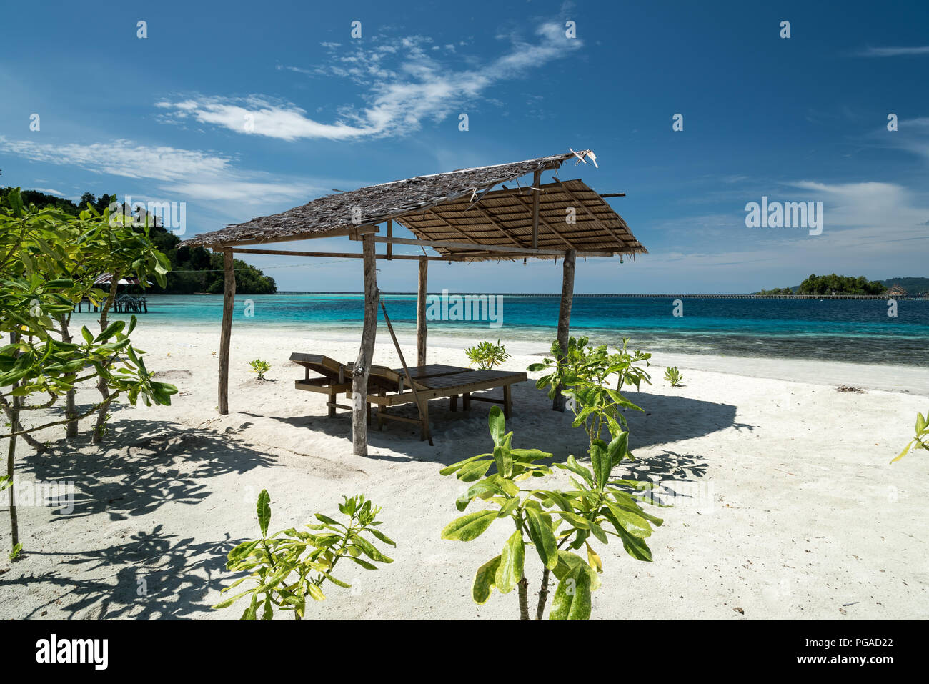 Tropical sand beach resort sulla remota Isola di Malenge, parte di Togean arcipelago con riparo e sdraio, Lestari, Indonesia Foto Stock