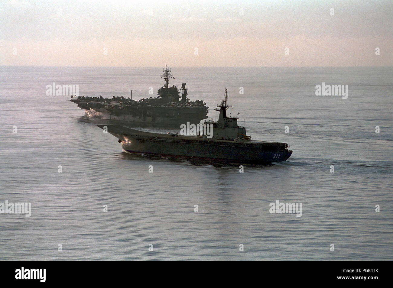 Il Thai Royal Naval nave HTMS CHAKRI NARUEBET (CVH 911), un elicottero carrier, operanti lungo il lato del USS Kitty Hawk (CV 63). Foto Stock