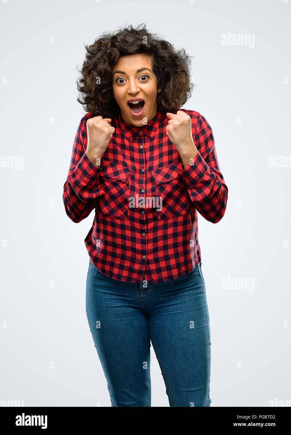 Bella donna araba felice ed entusiasta che esprimono gesto vincente. Successo e celebrando la vittoria, trionfale Foto Stock