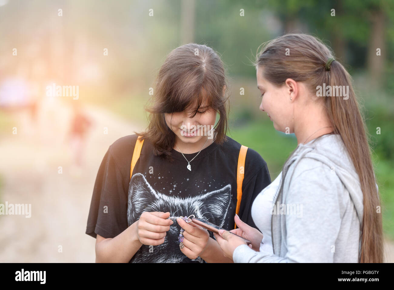 Due ragazze con i telefoni cellulari nelle loro mani, il concetto di amicizia e di comunicazione Foto Stock