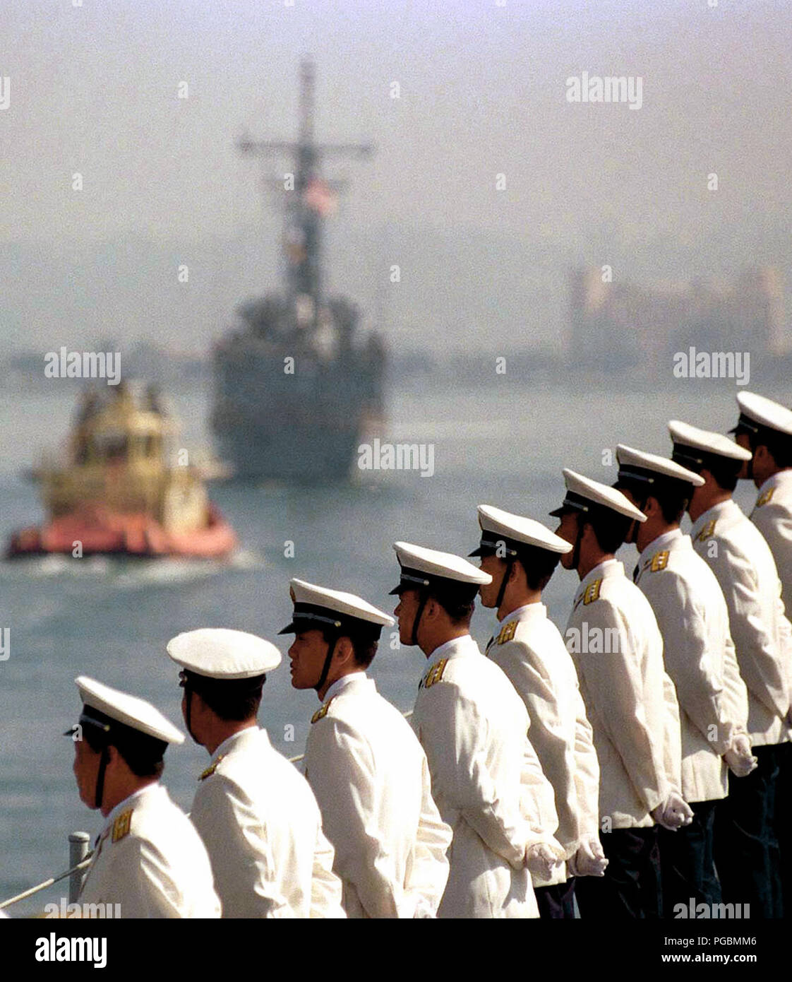 Funzionari cinesi uomo la rampa come NEGLI STATI UNITI Navy fregata USS GEORGE PHILLIP (FFG 12) (al di fuori della messa a fuoco in background) accompagnatori della Repubblica di Cina (Marina) Classe Luhu Destroyer, HARIBING (DDG 112), nella Baia di San Diego. Questo segna la prima volta navi cinesi hanno attraversato il Pacifico e ha visitato negli Stati Uniti continentali. Il cacciatorpediniere HARIBING, Luda II classe distruttore, ZHUHAI (DDG 166), e di una nave di alimentazione, la classe Fusu, NANYUN (AOR/AK 953), (ZHUHAI e NANYUN non mostrato) si è fermato a Naval Station, Isola del nord, San Diego, California, su marzo 21st, 1997. Foto Stock