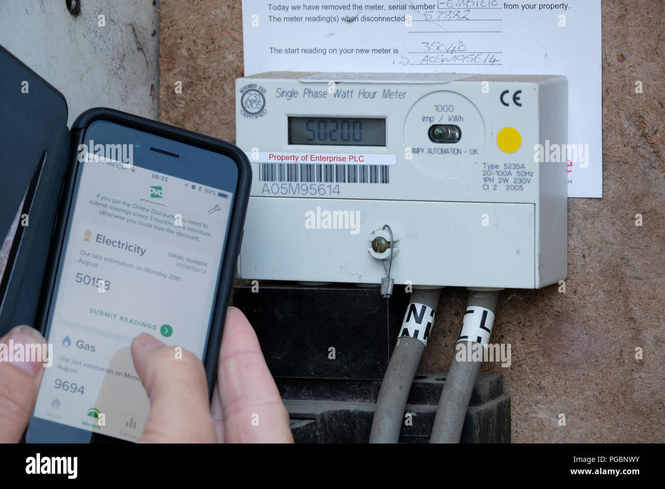La presentazione di gas e il contatore di energia elettrica, la lettura per la società di energia utilizzando un'app su un telefono intelligente Foto Stock