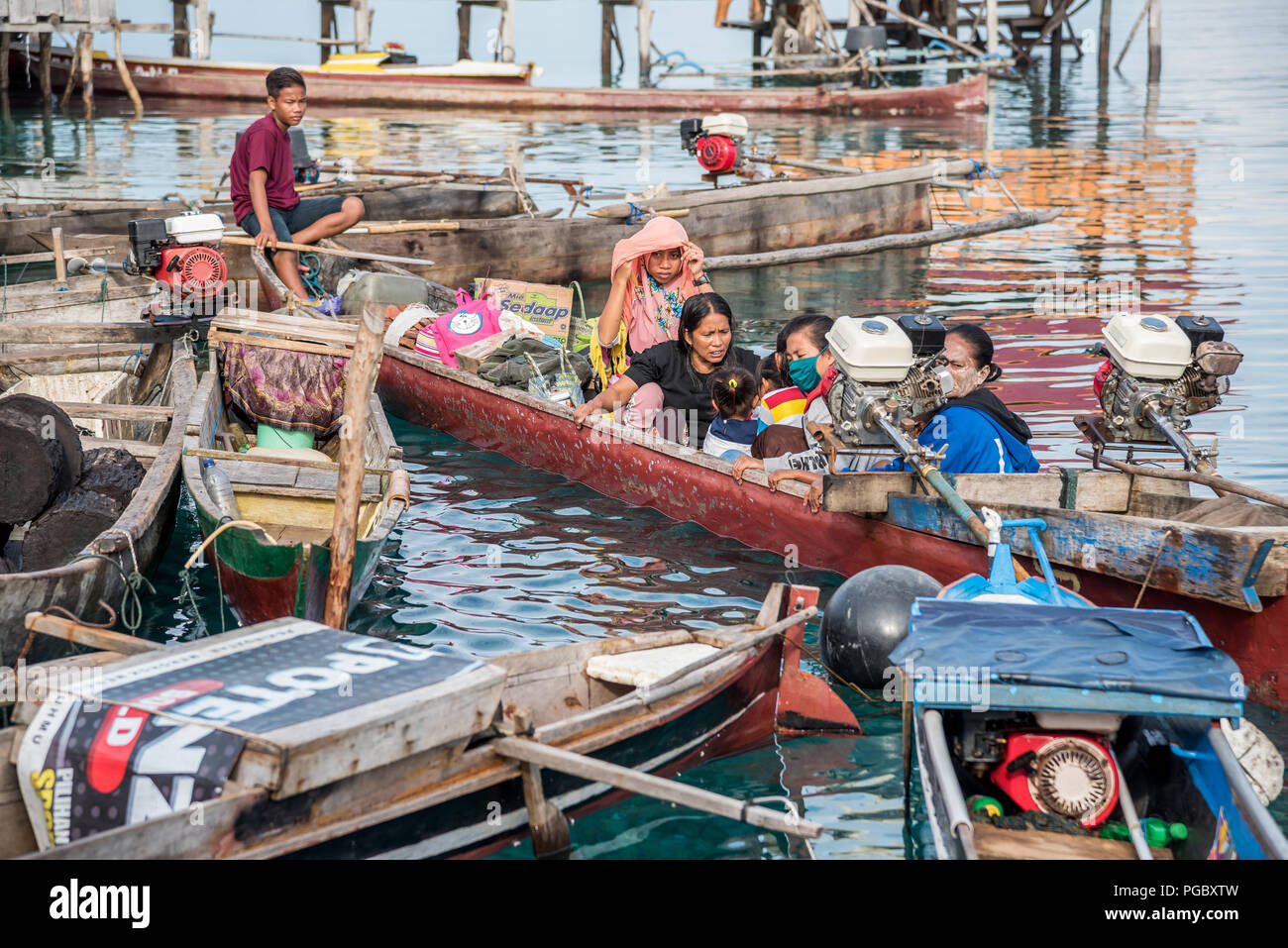 INDONESIA, ISOLE TOGEAN -MALENGE - Luglio 11, 2018: una famiglia sulla barca di legno tradizionale da bajo villaggio nel Sulawesi centrale Foto Stock