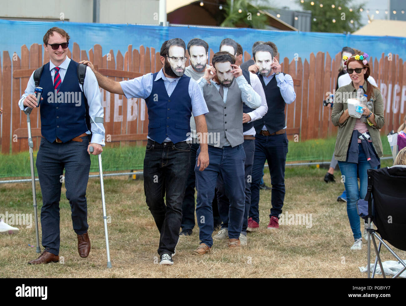 Un gruppo di uomini indossano maschere di Inghilterra manager Gareth Southgate durante il Big Feastival presso Alex James' farm in Kingham, Oxfordshire. Foto Stock