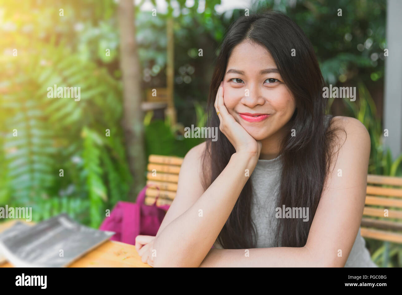 Bella asiatica Thai smile carino teen capelli neri nel giardino relax la postura Foto Stock