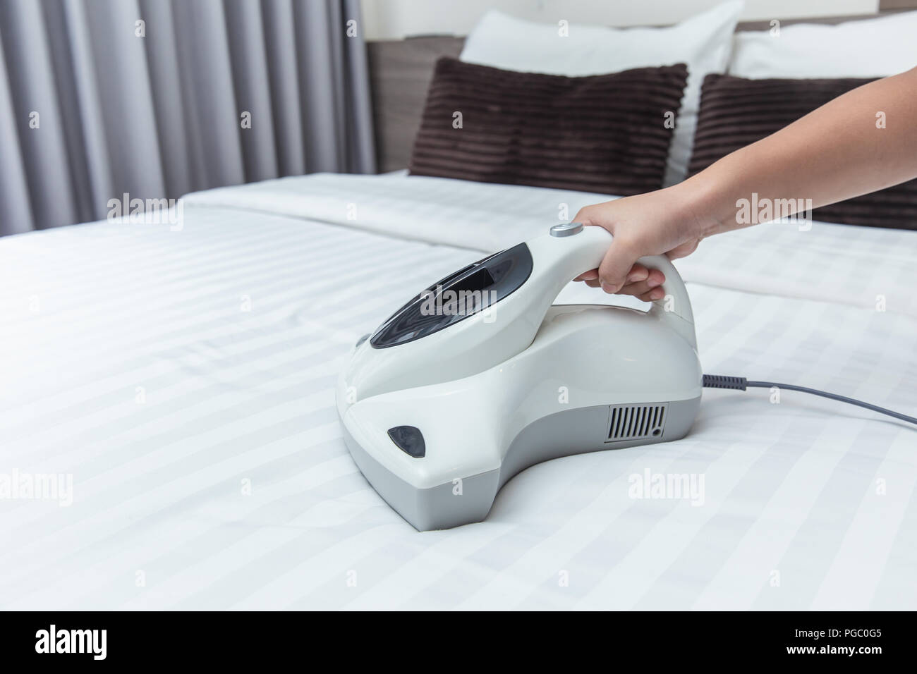 Acaro aspirapolvere utilizzando la pulizia letto materasso eliminatore di polvere con lampada UV Foto Stock