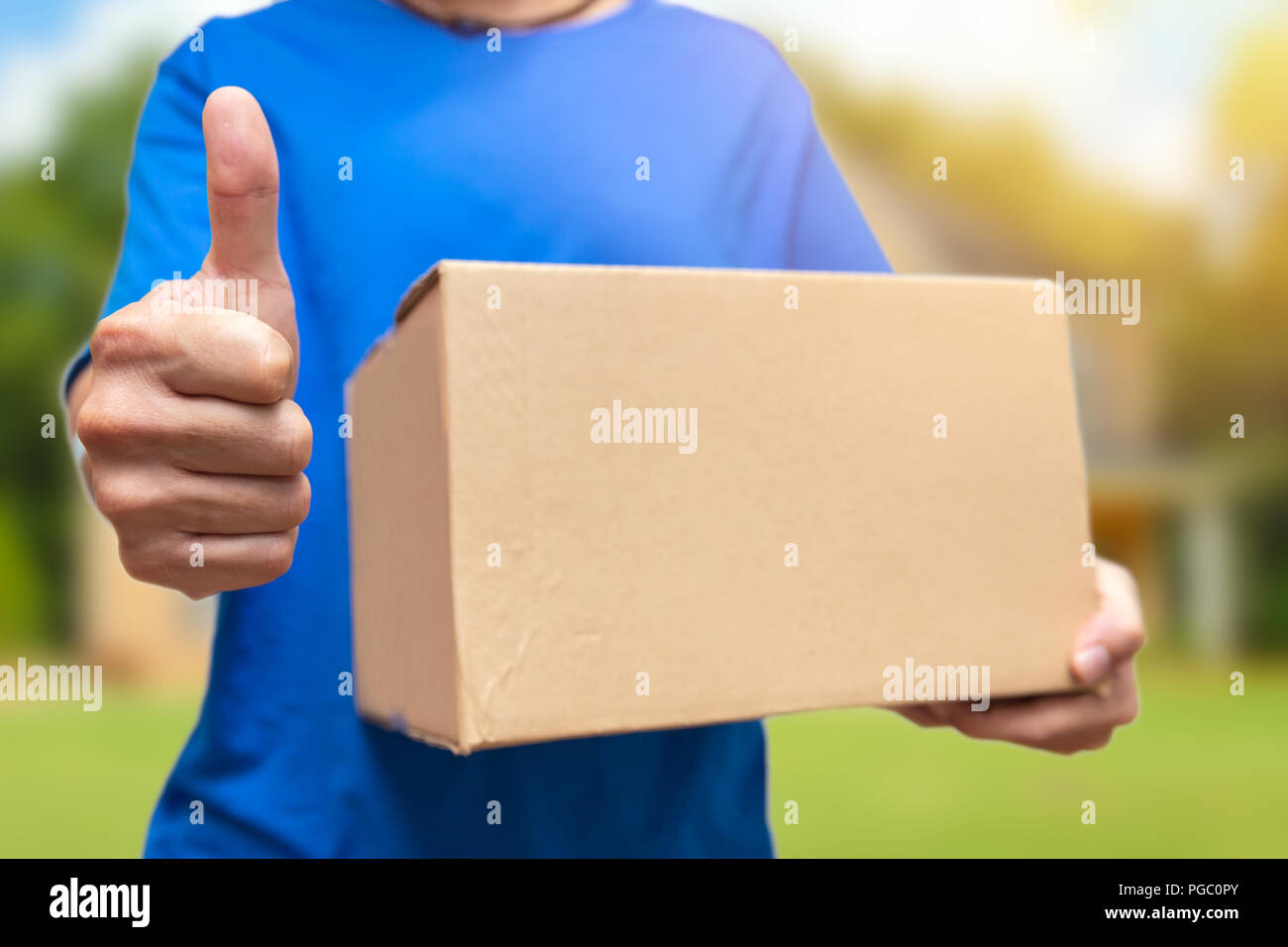 Buona voce o best shipping fast uomo azienda big box e pollice in alto Foto Stock