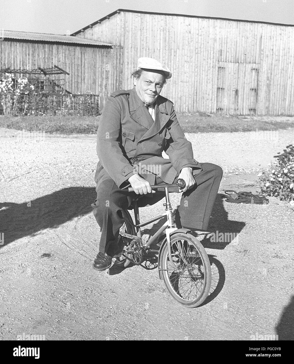 Anni Cinquanta uomo su una bicicletta. Attore Hampe Faustman è in sella ad una bicicletta per bambini. La Svezia 1952 Photo Kristoffersson BD66-9 Foto Stock