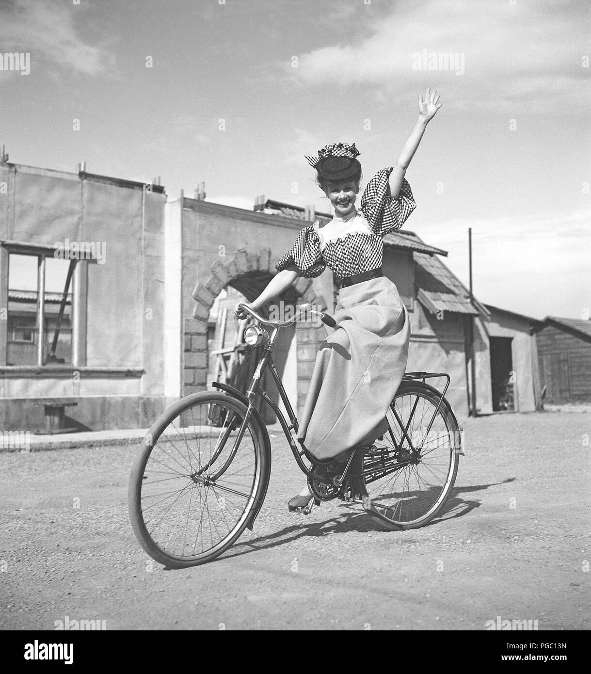 1940s donna in bicicletta. La giovane attrice Sonja Wigert sta guidando la sua bicicletta sui terreni degli studi cinematografici di Sandrew a Stoccolma. Svezia 1944. Foto Kristoffersson K22-6 Foto Stock