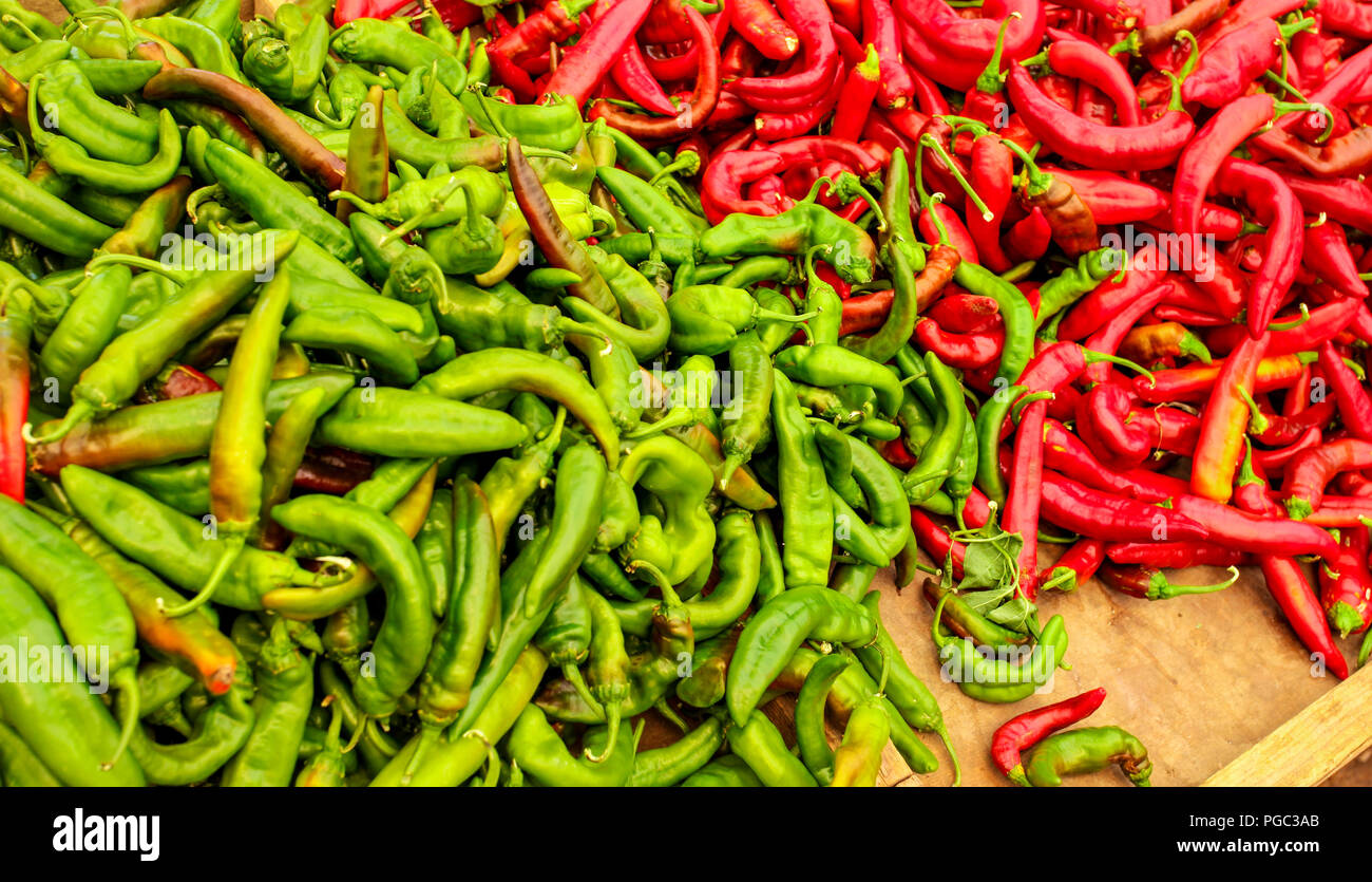 Sottolineato peperoni rossi e verdi, in contrasto di vivaci colori, visualizzato sul mercato alimentare. Foto Stock